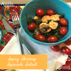 Spicy shrimp spinach salad in a blue bowl
