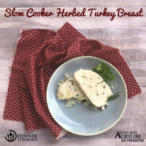 Two slices of our Slow Cooker Herbed Turkey Breast recipe plated with napkin.