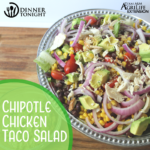 chipotle chicken taco salad recipe plated and ready for eating in a silver beaded bowl, resting on a wooden cutting board
