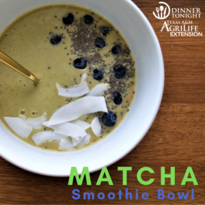 Matcha smoothie bowl topped with coconut flakes, blueberries, and chia seeds.