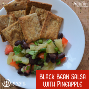 Black bean salsa with pineapple, plated with crackers.