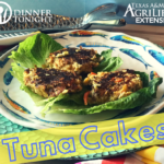 Tuna cakes sitting on a bed of lettuce served on a fish printed bowl