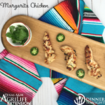 Margarita Chicken breast recipe on cutting board with side of sliced jalapenos, splayed over a colorful serape cloth