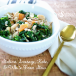 Italian Sausage Kale and White Bean stew in white bowl with a spoon and napkin ready to eat.